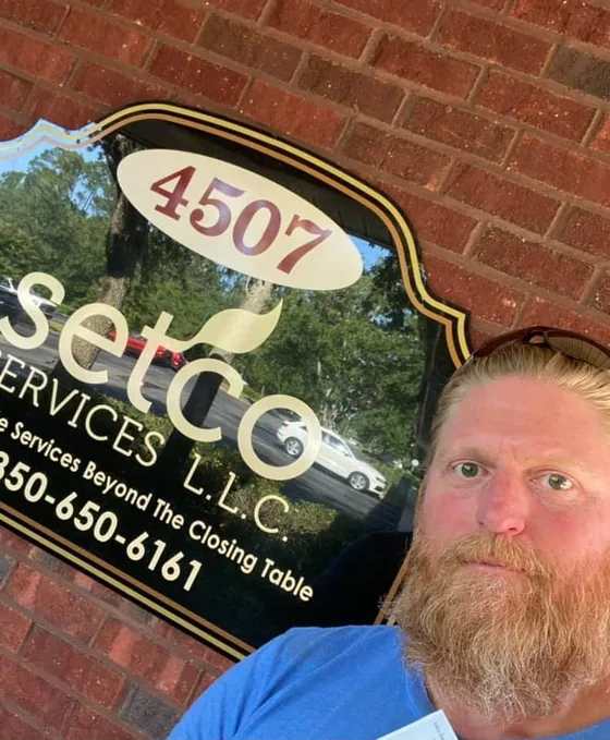Greg outside the title company, under the Setco Services sign at 4507.